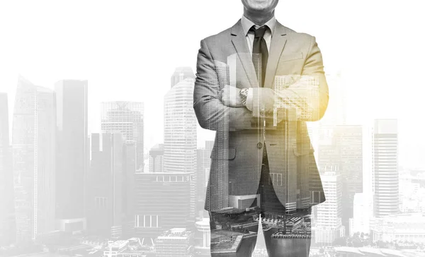 Businessman with crossed arms over city buildings — Stock Photo, Image