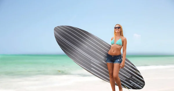 Sorrindo jovem mulher com prancha de surf na praia — Fotografia de Stock