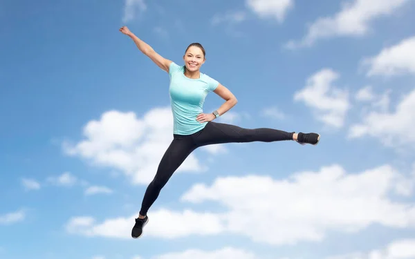 Glada sportiga ung kvinna hoppa i blå himmel — Stockfoto