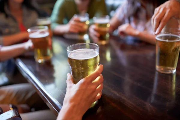 Vrienden drinken bier bij bar of pub — Stockfoto