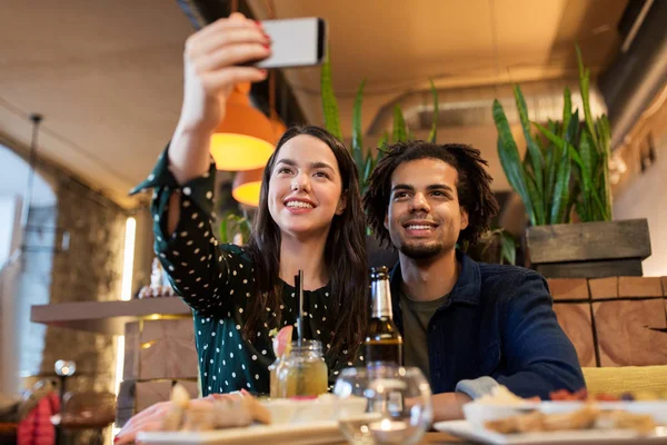 Šťastný pár pořizování selfie v kavárně nebo baru — Stock fotografie