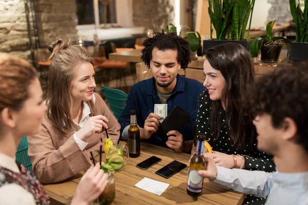 Arkadaş grubu içecekler, para ve banknotuna bar — Stok fotoğraf