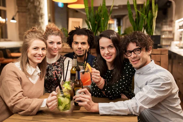 Amigos felizes com bebidas no bar ou café — Fotografia de Stock