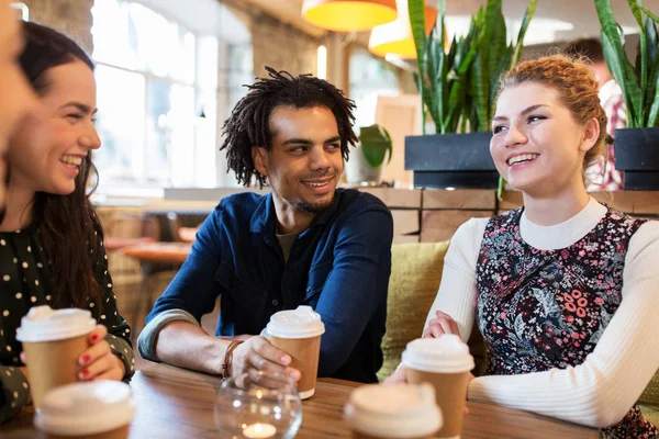 Happy friends drinking coffee at restaurant — Stock Photo, Image