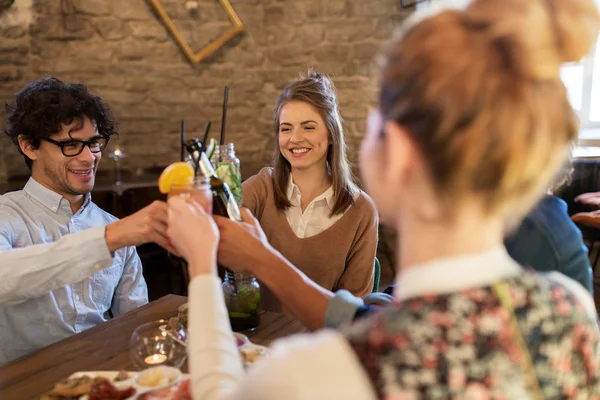 Счастливые друзья звонят напитки в баре или кафе — стоковое фото