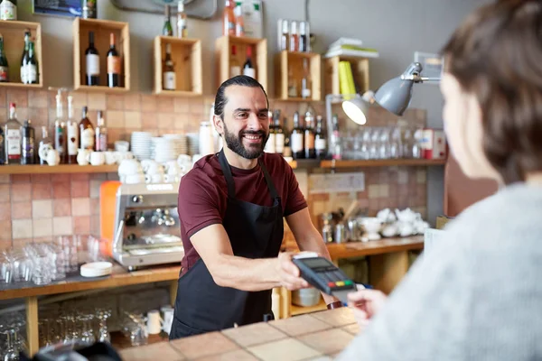 Чоловік або офіціант з читачем карток і клієнтом в барі — стокове фото