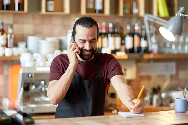 Hombre feliz o camarero en el bar llamando en el teléfono inteligente —  Fotos de Stock