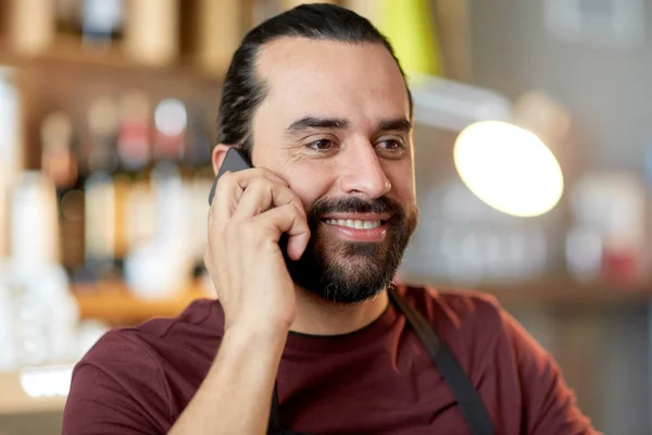 Lycklig man eller servitör på bar uppmanar smartphone — Stockfoto