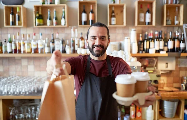 Man of ober met koffie en papieren tas bij bar — Stockfoto
