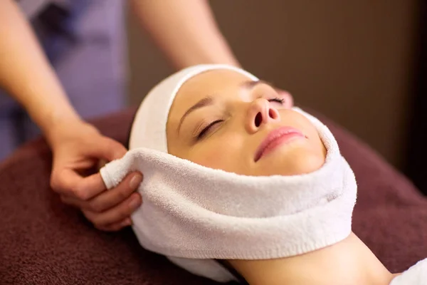 Woman having face massage with towel at spa — Stock Photo, Image