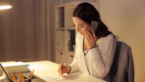 Женщина со смартфоном и бумагами в ночном офисе — стоковое видео