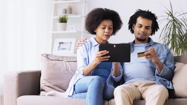 Pareja con tablet pc y tarjeta de crédito en casa — Vídeo de stock