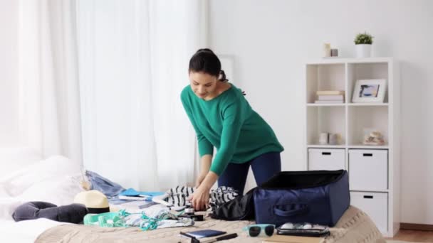 Kobieta, pakowanie torby podróżnej w domu lub pokoju hotelowym — Wideo stockowe