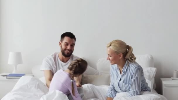 Щаслива сім'я розважається в ліжку вдома — стокове відео