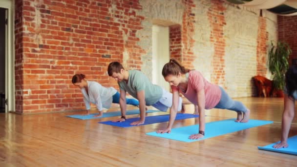 Bir grup insan spor salonunda yoga egzersizleri yapma — Stok video