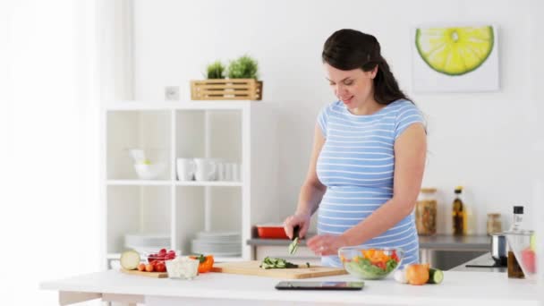 Pregnant woman cooking vegetable salad at home — Stock Video