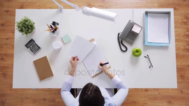 Mujer de negocios con papeles trabajando en el escritorio de la oficina — Vídeos de Stock