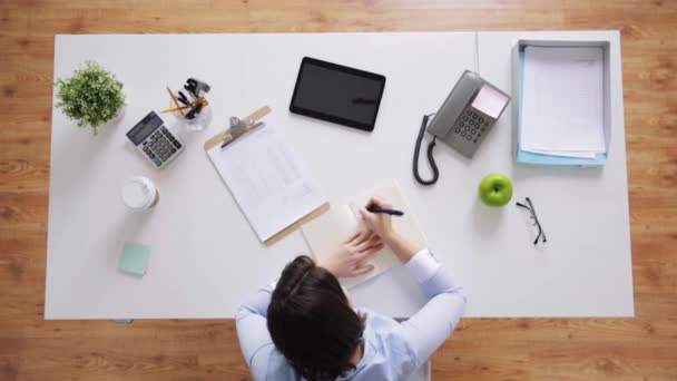 Businesswoman with notebook and papers at office — Stock Video