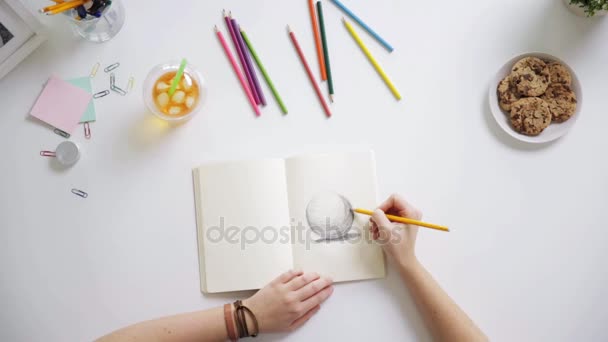 Žena kreslení obrázek v poznámkovém bloku na domácí stůl — Stock video