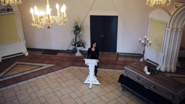 Sad woman and coffin at funeral in orthodox church — Stock Video