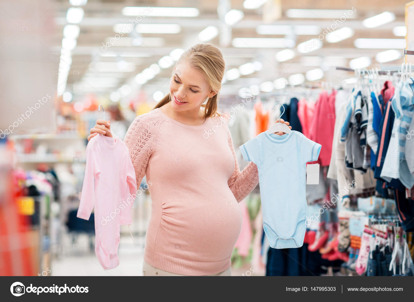 Pregnant Woman With Baby Clothes At Clothing Store Stock Photo Image By C Syda Productions 147995303