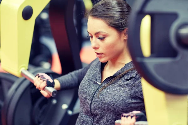 Mulher flexionando músculos no peito imprensa máquina de ginásio — Fotografia de Stock