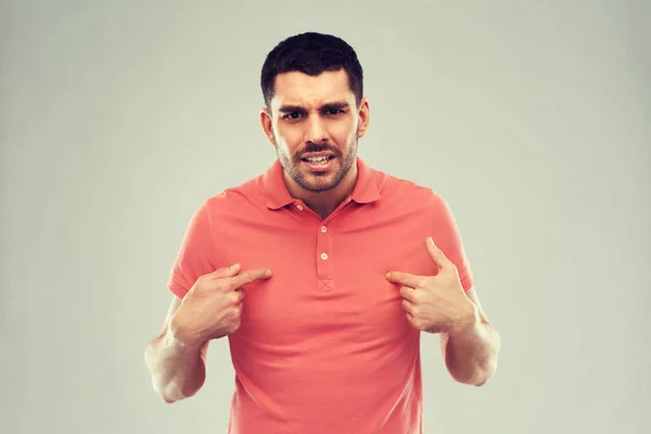 Angry man pointing finger to himself over gray — Stock Photo, Image