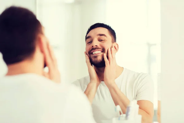 Feliz joven mirando al espejo en el baño en casa — Foto de Stock