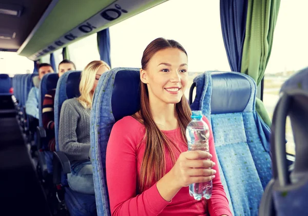 Ευτυχισμένος νεαρή γυναίκα με μπουκάλι νερό στο λεωφορείο ταξιδιωτικό — Φωτογραφία Αρχείου