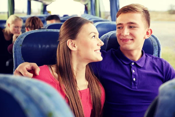 Happy teenage couple or passengers in travel bus — Stock Photo, Image