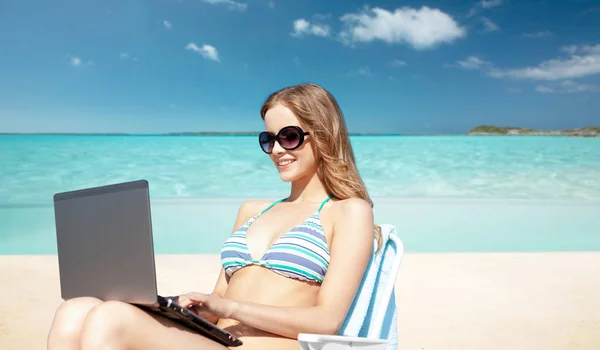 Mulher com laptop banhos de sol no salão na praia — Fotografia de Stock