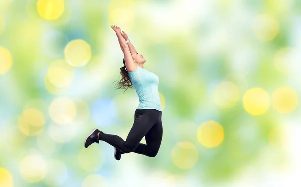 Gelukkig glimlachen sportieve jonge vrouw springen in de lucht — Stockfoto