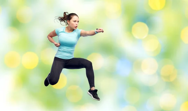 Fröhliche sportliche junge Frau springt in Kampfpose — Stockfoto