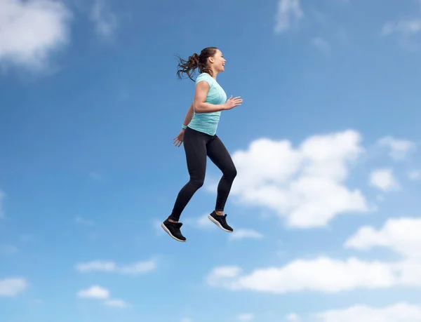 幸せな笑顔スポーティな若い女性が空中ジャンプ — ストック写真