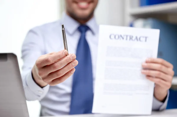 Homem de negócios com papel contratual e caneta no escritório — Fotografia de Stock