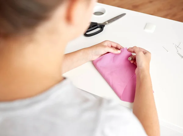 Žena s jehlou šití kousky tkaniny — Stock fotografie