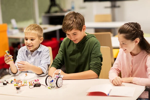 Gelukkige kinderen bouwen robots op robotica school — Stockfoto