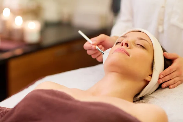 Esteticista aplicando máscara facial para a mulher no spa — Fotografia de Stock