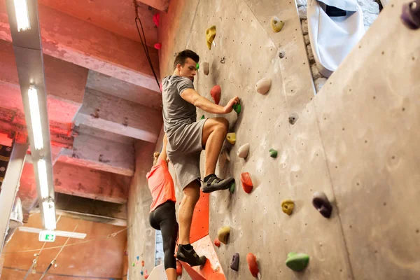 Homem e mulher se exercitando no ginásio de escalada indoor — Fotografia de Stock