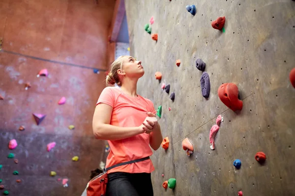 Jovem mulher exercitando na parede do ginásio de escalada interior — Fotografia de Stock