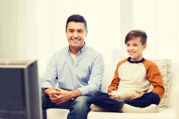 Souriant père et fils regarder la télévision à la maison — Photo