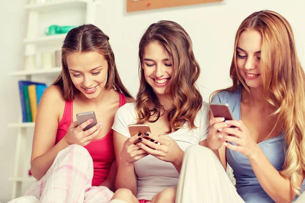 Amigos ou meninas adolescentes com smartphone em casa — Fotografia de Stock