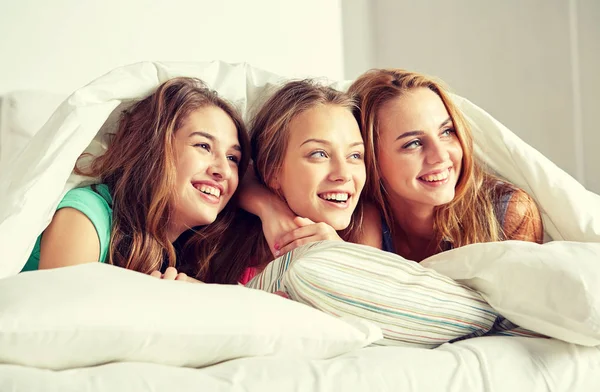 Felici giovani donne a letto a casa pigiama party — Foto Stock