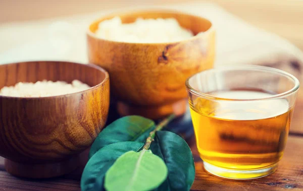 Närbild på honung i glas med blad på trä — Stockfoto