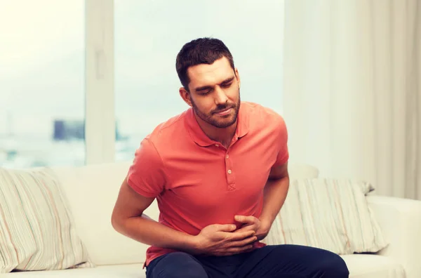 Infeliz homem que sofre de dor de barriga em casa — Fotografia de Stock