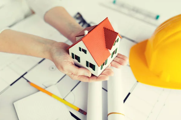 Close up of hands with house model above blueprint — Stock Photo, Image