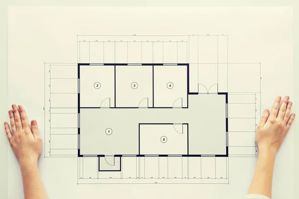 Zbliżenie na ręce z planu architektonicznego — Zdjęcie stockowe