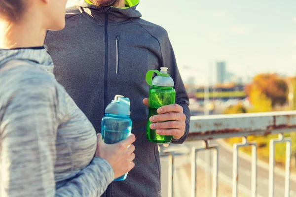 Primer plano de pareja con botellas de agua al aire libre — Foto de Stock