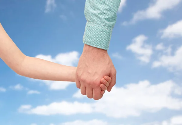 Padre e hijo tomados de la mano sobre el cielo azul —  Fotos de Stock