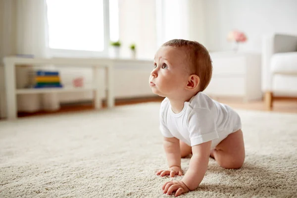 Bezli küçük bebek evde yerde sürünüyor. — Stok fotoğraf